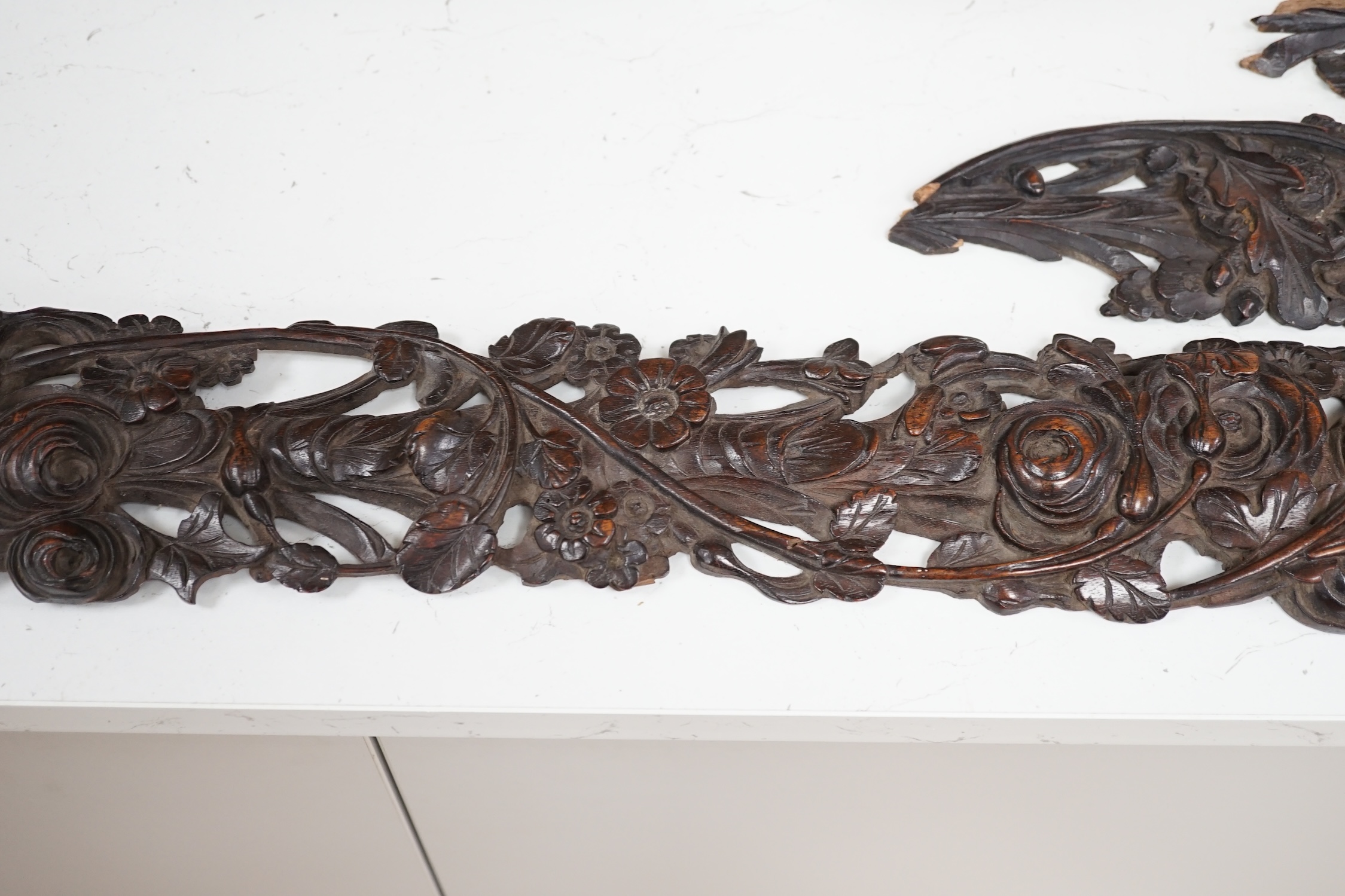 A carved walnut frieze and section with floral decoration, 131cm long. Condition - poor to fair, broken into sections and some woodworm